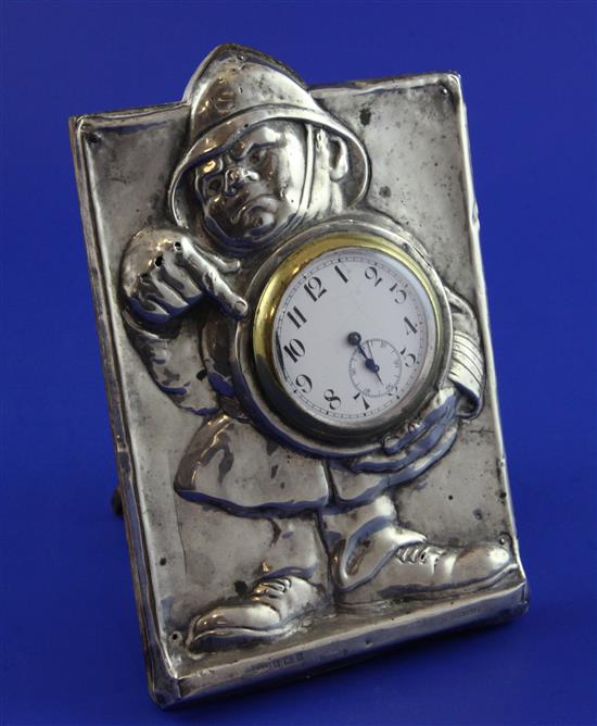 An Edwardian silver mounted rectangular watch holder frame embossed with the figure of a policeman, 6.5in.